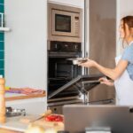Woman using modern kitchen appliances